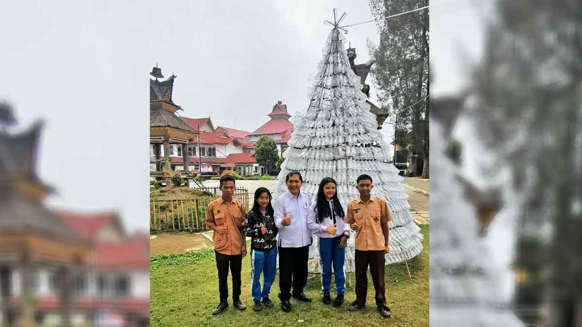 SWAFOTO: Bupati Karo terkelin Brahmana berswafoto bersama pelajar di depan Pohon Natal yang dibuat TP PKK Karo. SURYA/SUMUT POS