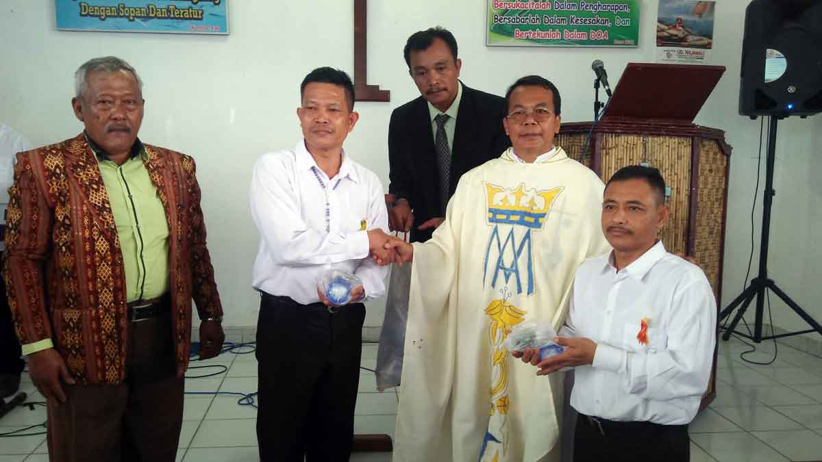 SIMBOLIS: Pastor Eligius Ipong O. carm didampingi KDS St Louis Martin Panji Bako, Selasa Limbong dan Ketua Panitia Natal,  Robertus Sitanggang secara simbolis memberikan bingkisan Natal kepada warga binaan. RUDY SITANGGANG/SUMUT POS