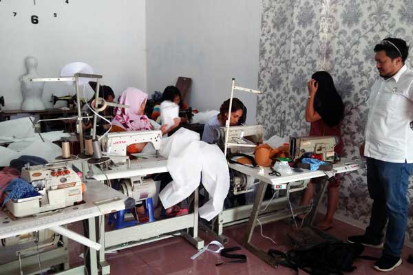 PERAJIN: Anggota DPRD Dairi dari fraksi PDIP, Hendra Tambunan (kanan) saat memantau usaha tukang jahit Rumah Mode Tabitha di Jalan Sisingamangara Sidikalang  yang diberdayakan untuk membuat APD penanganan Covid-19. RUDY SITANGGANG/SUMUT POS