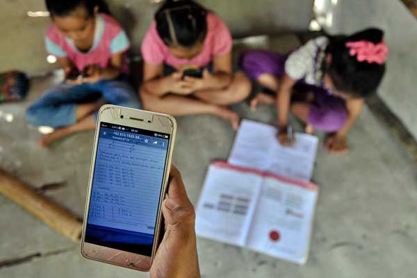 MEREKAM  TUGAS: Orangtua merekam anak-anaknya mengisi tugas-tugas sekolahnya melalui ponsel atau belajar secara online.