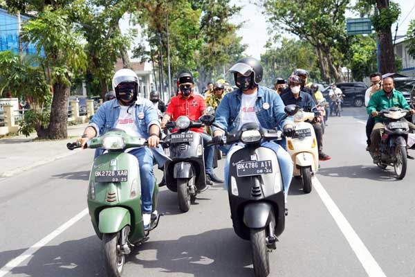 NAIK VESPA: Bobby Nasution dan Aulia Rachman mengendarai Vespa menuju kantor KPU Medan di Jalan Kejaksaan, untuk mendaftar sebagai pasangan calon Wali Kota dan Wakil Wali Kota Medan, Jumat (4/9).