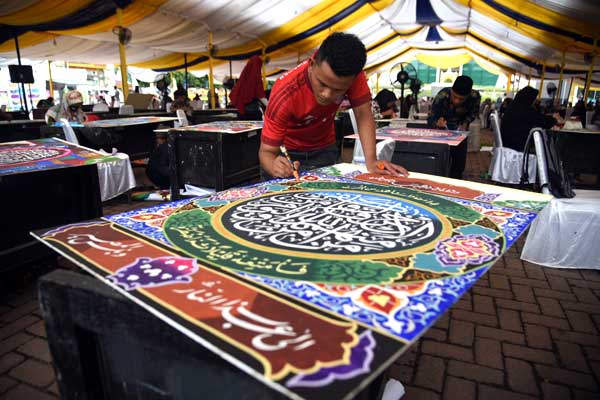 SERIUS: Para peserta serius menyelesaikan karyanya pada lomba kaligrafi golongan dekorasi pada MTQ  ke-37 Provinsi Sumatera Utara, di Lapangan Merdeka Kota Tebingtinggi, Minggu (6/9). 
