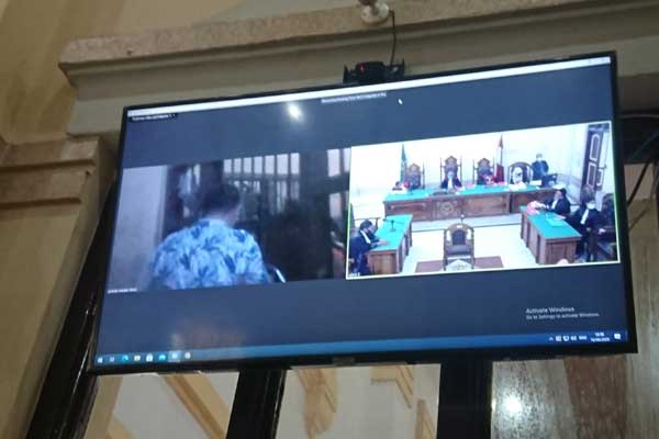BELAKANGI: Husen Syukri (layar monitor) terdakwa kepemilikan ekstasi membelakangi majelis hakim saat men jalani sidang tuntutan secara virtual,  Rabu (16/9).