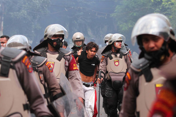 DIAMANKAN: Petugas Kepolisian mengamankan seorang demonstran saat aksi menolak Undang-undang Cipta Kerja di depan Kantor DPRD Sumut, Jalan Imam Bonjol Medan, Kamis (8/10).