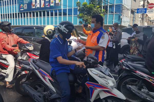 SOSIALISASI: Petugas PT KAI sosialisasi tertib lalu lintas di perlintasan sebidang kereta api.bagus/sumutpos.