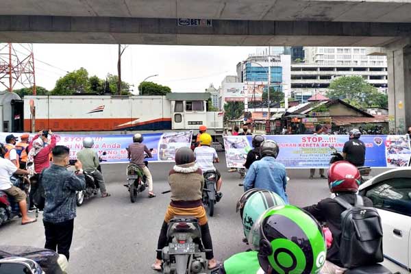 PERLINTASAN KA: Pengendara berhenti di depan perlintasan kereta api (KA).bagus/sumu tpos.