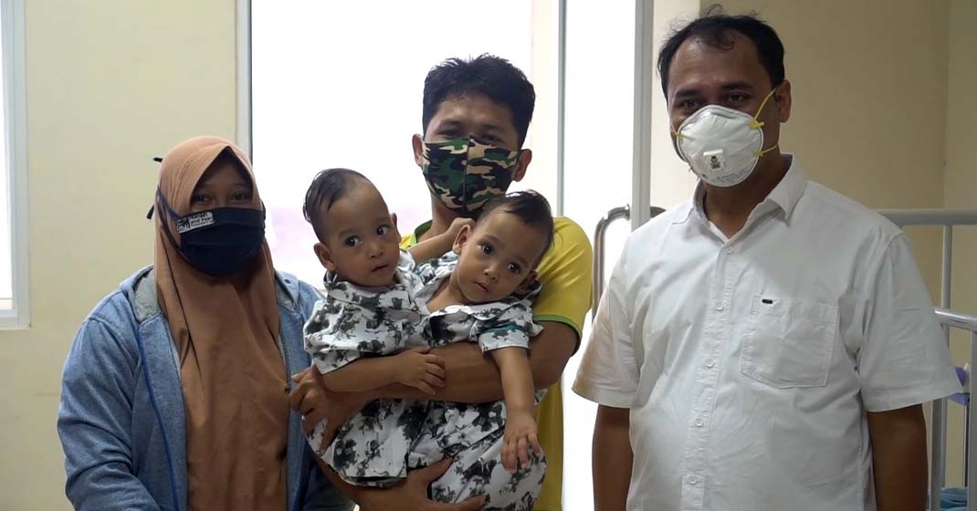 DIGENDONG: Bayi kembar siam bernama Adam dan Aris, asal Labuhanbatu-saat digendong ayahnya. Kedua bayi ini akan dioperasi pemisahan oleh tim  medis Rumah Sakit Umum Pusat Haji Adam Malik (RSUP HAM), Medan.