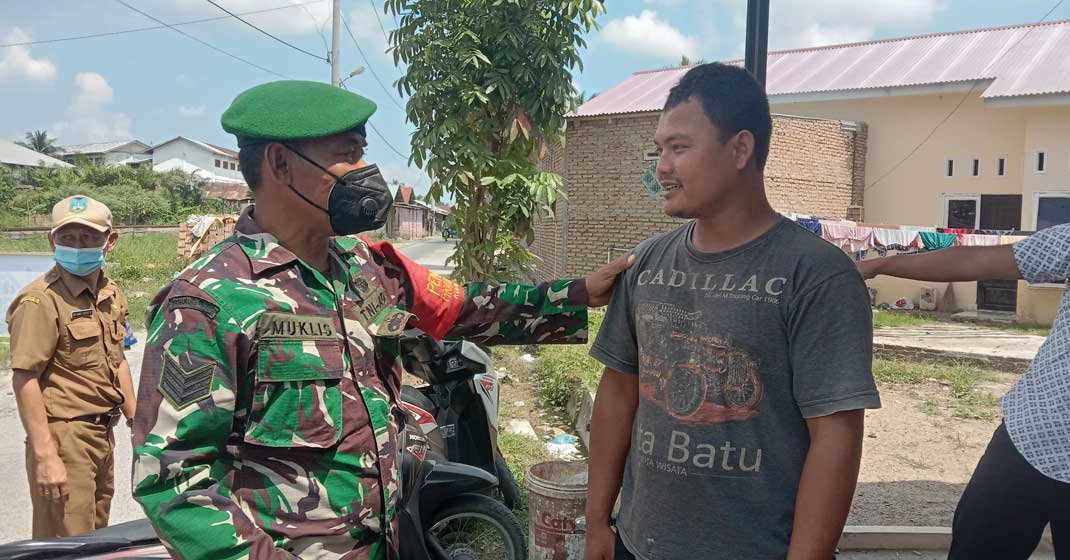 RAZIA MASKER: Petugas menegur warga yang tak mengenakan masker saat jajaran Kelurahan Lalang bersama Bhabinkamtimbas, dan Babinsa, melakukan razia masker di Jalan LKMD.
