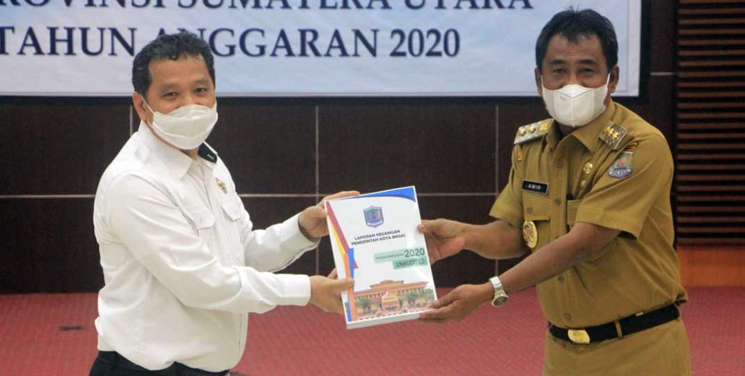 SERAHKAN: Plt Wali Kota Binjai, H Amir Hamzah menyerahkan LKPD kepada Kepala BPK RI Perwakilan Sumut.SOLIDEO/SUMUT POS.