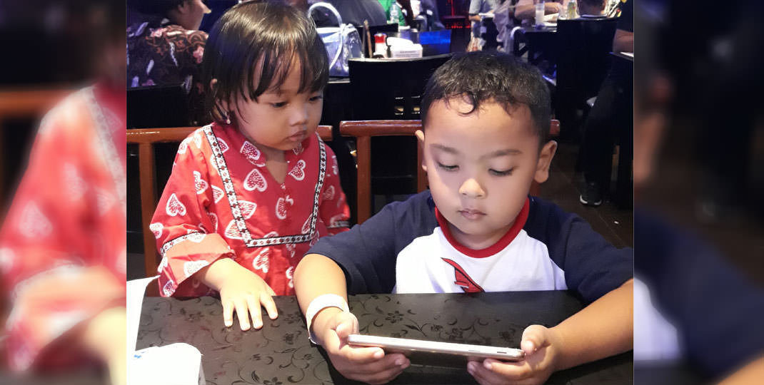 BERMAI GAME: Seorang anak asyik bermain game menggunakan ponsel android. M IDRIS/sumu tpos.