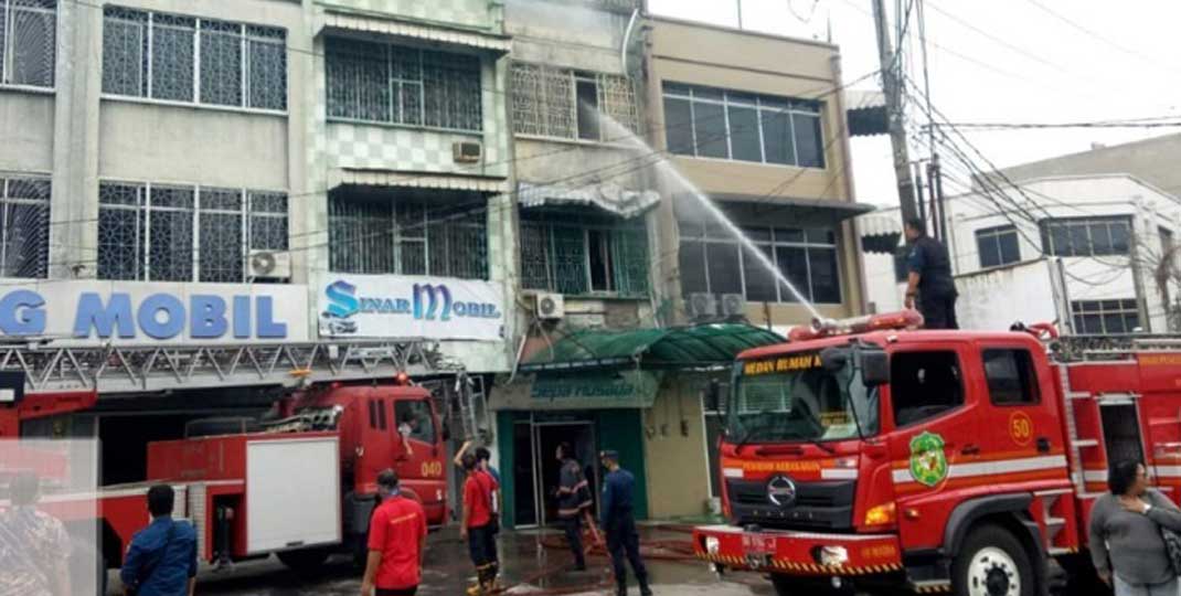 PADAMKAN API: Petugas damkar Kota Medan memadamkan api yang membakar Ruko berlantai tiga di Jalan Nibung Raya, Medan Petisah terbakar, Jumat (5/3) pagi.
