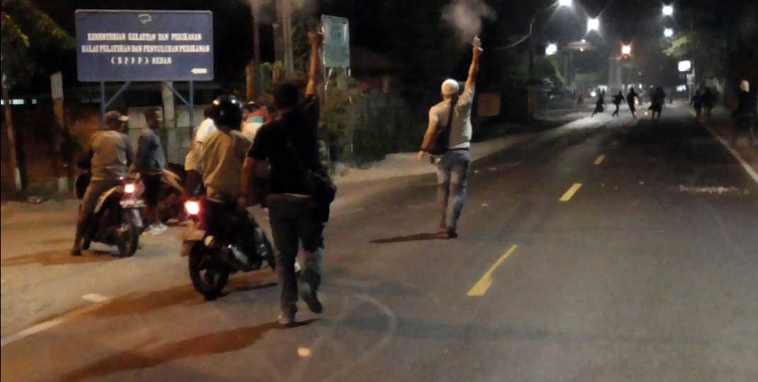 TAWURAN: Polisi menembakkan ke atas udara saat melerai aksi tawuran di Medan Labuhan, Minggu (21/3). fachril/sumu tpos.