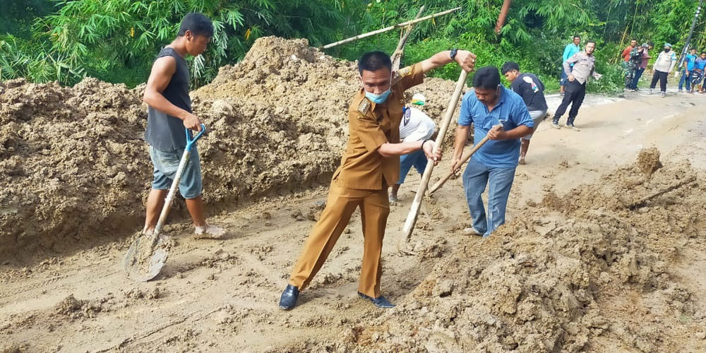 LONGSOR: Camat Tigalingga, Timbul Tamba (tengah) bersama unsur Forkopimcam, pemerintahan Desa Palding Jaya, dan masyarakat membersihkan material longsor yang menutup badan jalan yang menghubungkan Sidikalang-Kutabuluh, Selasa (18/5).ISTIMEWA.