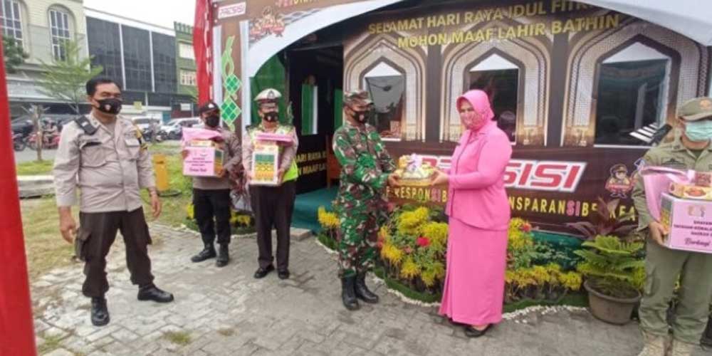 SERAHKAN: Ketua Bhayangkari Sumatera Utara, Rita Panca Putra, menyerahkan bingkisan di Pos Pam di Jalan Krakatau/Simpang Cemara Kecamatan Medan Timur, Senin (10/5). dewi/sumutpos.