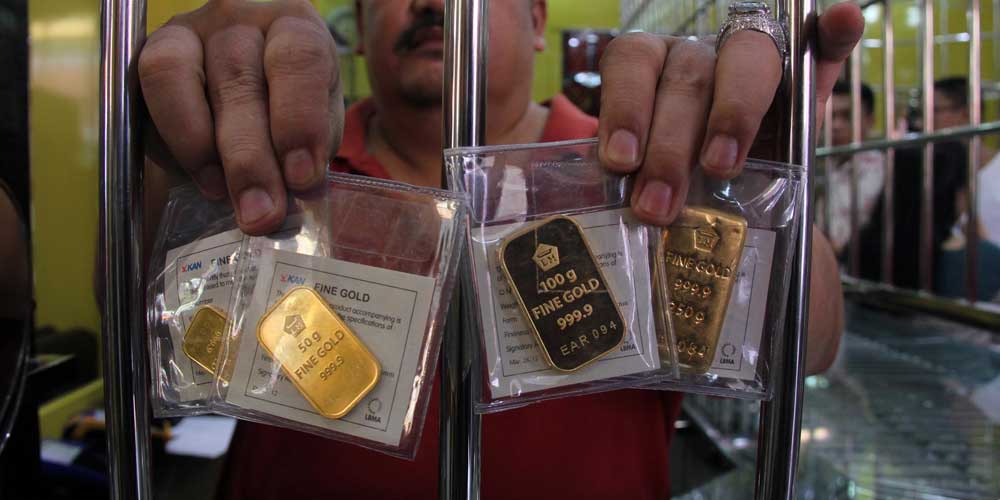 TUNJUKKAN: Penjual menunjukkan batangan emas Antam di toko emas Jalan Pringgan Medan, belum lama ini.