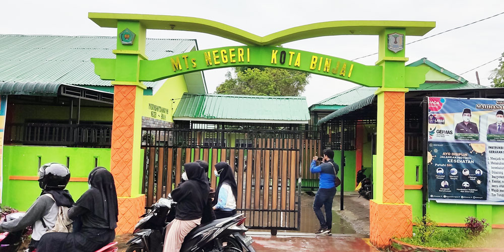 MELINTAS: Warga saat melintas di depan  Sekolah Madrasah Tsanawiyah Negeri Kota Binjai,  Senin (7/6).TEDDY AKBARI/SUMUT POS.