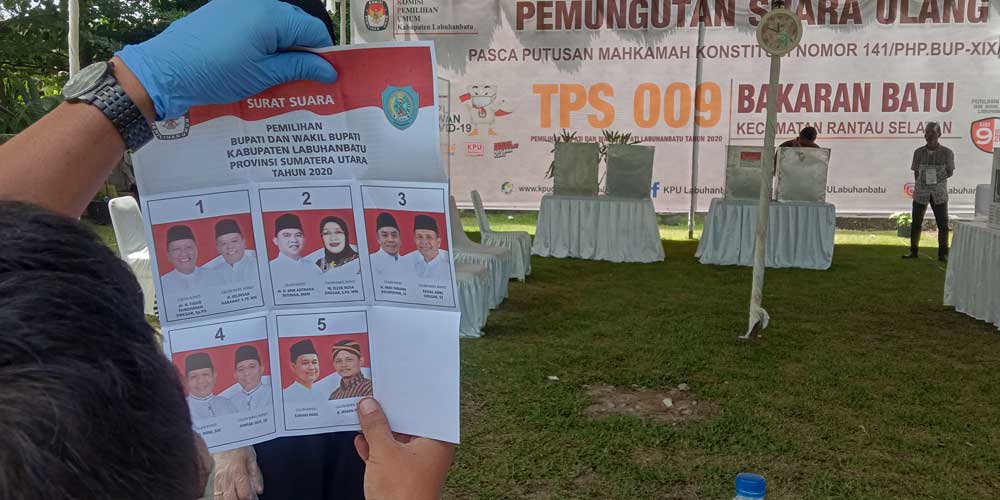 HITUNG SUARA: Seorang petugas KPPS melihat kertas suara yang dicoblos saat dilakukan penghitungan suara, Sabtu (19/6).fajar dame/sumut pos.