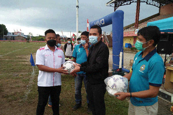 TERIMA BOLA: Direktur Operasional PT MKG Joseph Pangaribuan (kiri) menerima bola dari Wakil Bupati Dairi Jimmy Andrea Lukita Sihombing, sebelum membuka secara resmi turnamen sepak bola Sinar Muda Cup 1 di Stadion Panji, Sitinjo, Sabtu (19/6).
