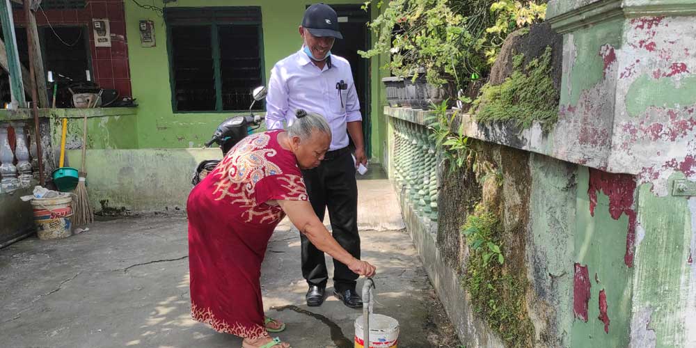 DERAS:  Nek Ondo didampingi Kacab PDAM Medan Amplas, Perdinan Ginting melalui Kepala Bagian Jaringan dan PKA, Sofyan, membuka keran air yang terlihat mengucur deras setelah dilakukan perbaikan oleh PDAM Tirtanadi Sumut, belum lama ini.