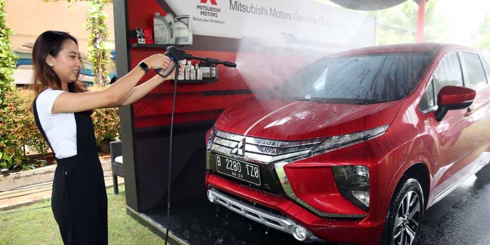 SEMPROT: Pelanggan saat mencoba untuk menyemprotkan disenfektan ke mobilnya.