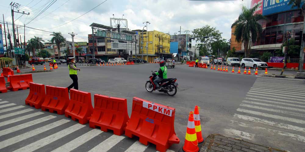 PENYEKATAN: Personel Polantas berjaga di lokasi penyekatan di persimpangan Jalan Juanda dan Jalan Brigjen Katamso dalam rangka PPKM Level 4 di Kota Medan.Triadi Wibowo/Sumut Pos .