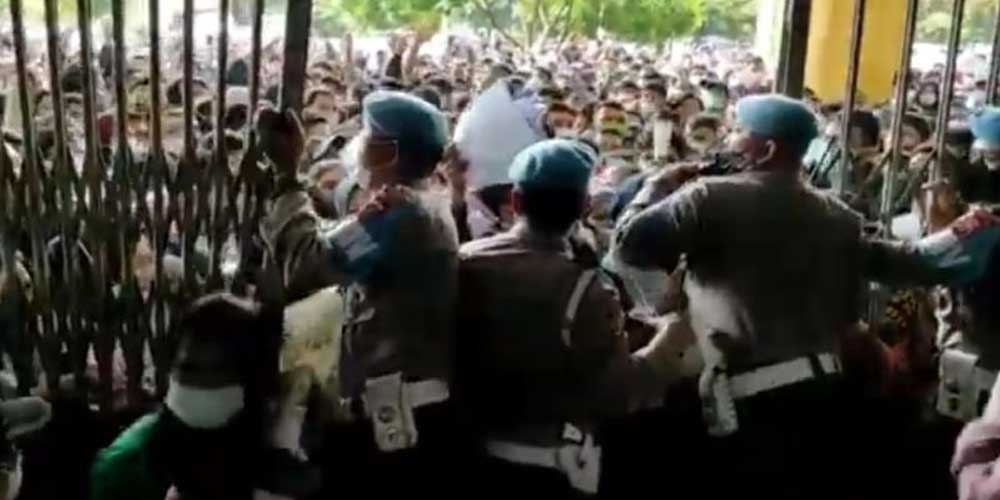 BERDESAKAN: Petugas berupaya mengadang warga yang berdesakan hendak menerobos masuk ke GOR Serbaguna Pancing, Selasa (3/8).istimewa/sumu tpos.