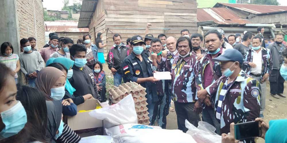 SERAHKAN: Ketua DPD IPK Karo Gembira Ginting, saat menyerahkan bantuan ke keluarga korban longsor Gang Lau Bawang, Kabanjahe. SOLIDEO/SUMUT POS.