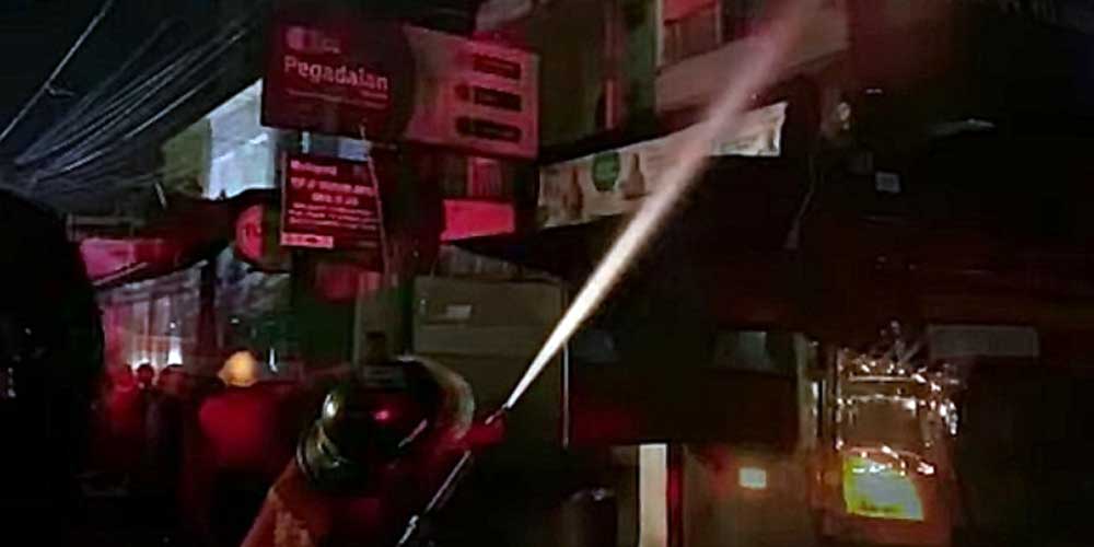 SEMPROT AIR: Petugas pemadam kebakaran menyemprotkan air untuk memadamkan api yang membakar salah satu bengkel di Jalan Ayahanda, Medan Petisah, Rabu (13/10) malam. idris/sumutpos.
