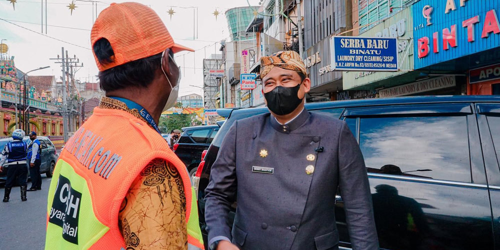 PETUGAS PARKIR: Wali Kota Medan Bobby Nasution berbincang dengan seorang juru parkir E-Parking di kawasan Kesawan, baru-baru ini.