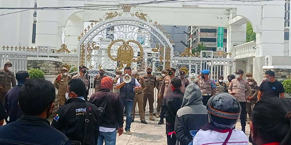 ORASI: Koordinator aksi, Willy Agus Utomo menyampaikan orasinya di depan kantor Gubernur Sumatera Utara, Jalan Pangeran Diponegoro, Medan, Selasa (30/11). Dalam aksi ini, mereka mendesak Gubsu untuk merivisi UMP 2022 dan tidak buru-buru meneken SK UMK yan