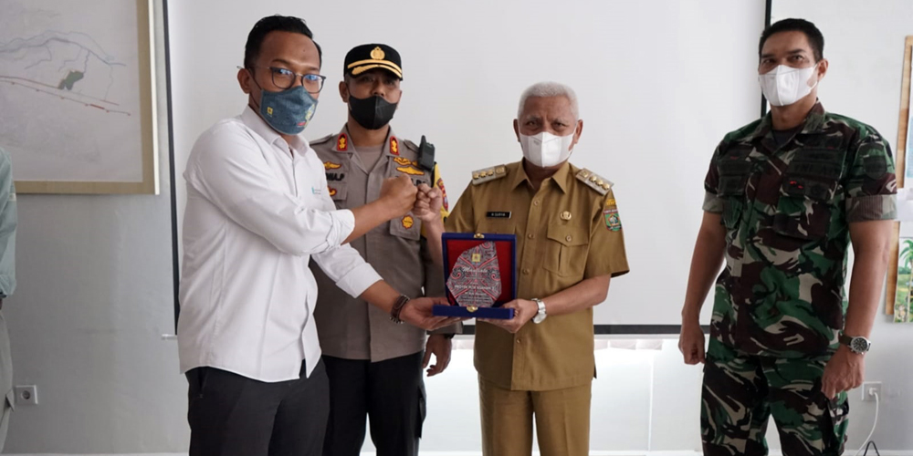 PLAKAT: Bupati Asahan H Surya BSc didampingi Kapolres Asahan, dan Dandim Asahan memberikan plakat kepada pihak PLTA Asahan III di Desa Meranti Utara Kecamatan Aek Songsongan, Senin (27/12).ist/SUMUT POS.