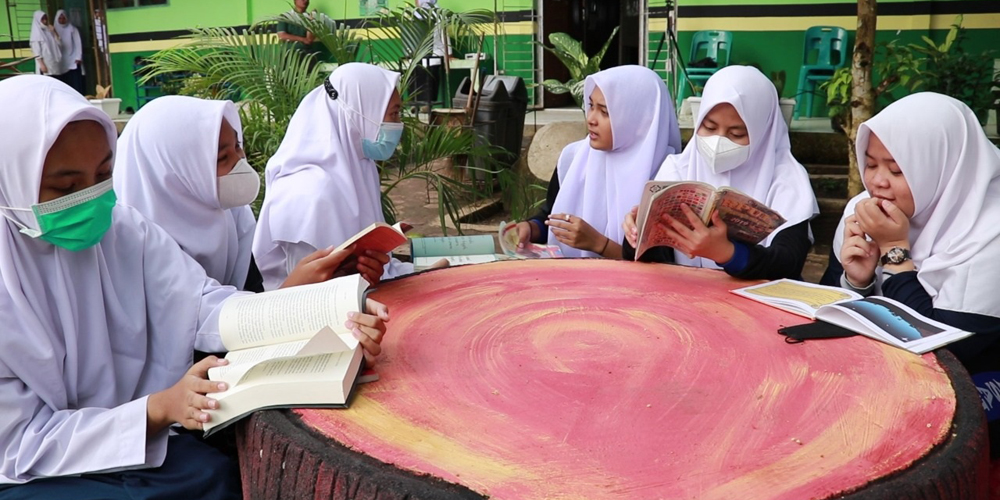 MEMBACA: Anak-anak membaca di  taman Pojok Baca hasil rancangan  Risma, guru di Madrasah Tsanawiyah Negeri di Kota Kisaran.