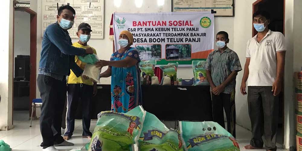 SALURKAN: Humas PT SMA, Linus Sinetor dan Asisten CSV Rifky Anandhika memberikan bantuan 60 paket sembako kepada warga terdampak banjir, di Kantor Desa Telukpanji, Senin (21/3).