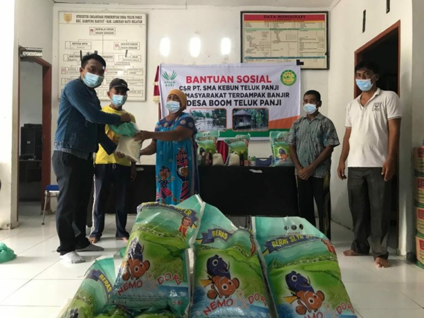 Humas PT SMA, Linus Sinetor dan Asisten CSV Rifky Anandhika memberikan bantuan 60 paket sembako kepada warga terdampak banjir, di Kantor Desa Teluk Panji, Senin (21/03/2022).