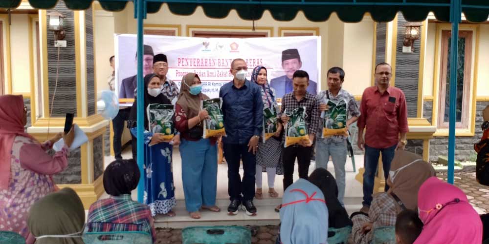 BERIKAN: Anggota DPR RI Komisi VIII, M Husni ketika memberikan bantuan beras kepada warga Kecamatan Padang Hilir Kota Tebingtinggi.sopian/sumut pos.