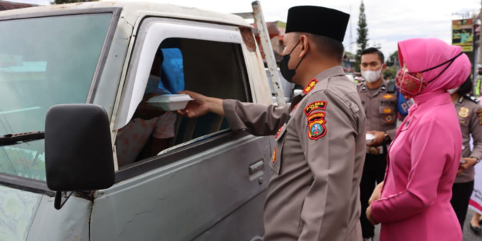 BAGI TAKJIL: Kapolres Dairi AKBP Wahyudi Rahman didampingi Ketua Cabang Bhayangkari, Ny Intan Wahyudi Rahman menyerahkan takjil kepada salahsatu pengendara.
