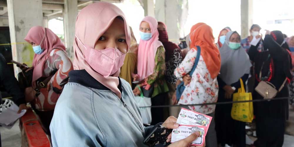 TIKET BUS: Seorang warga menunjukkan tiket bus mudik gratis yang digelar Pemko Medan. Mulai hari, sebanyak 1.250 orang diberangkatkan ke kampung halamannya.