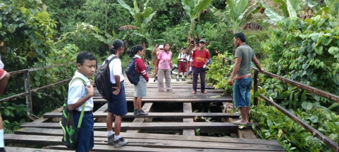 BERLUBANG. Tampak sejumlah warga Desa Lae Rambong, Kecamatan Silima Pungga-Pungga, Kabupaten Dairi, terpaksa menggendong anak mereka karena ketakutan saat melintas dari jembatan rusak ketika pergi dan pulang sekolah.SUMUTPOS.CO/ISTIMEWA.