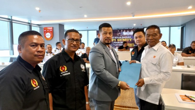 SERAHKAN: Ketua Umum PBFI Sumut, Drs Herri Zulkarnain SH MSi menyerahkan berkas kepada Wakil Ketua KONI Sumut Sakiruddin pada Raker I PBFI Sumut. (IST).
