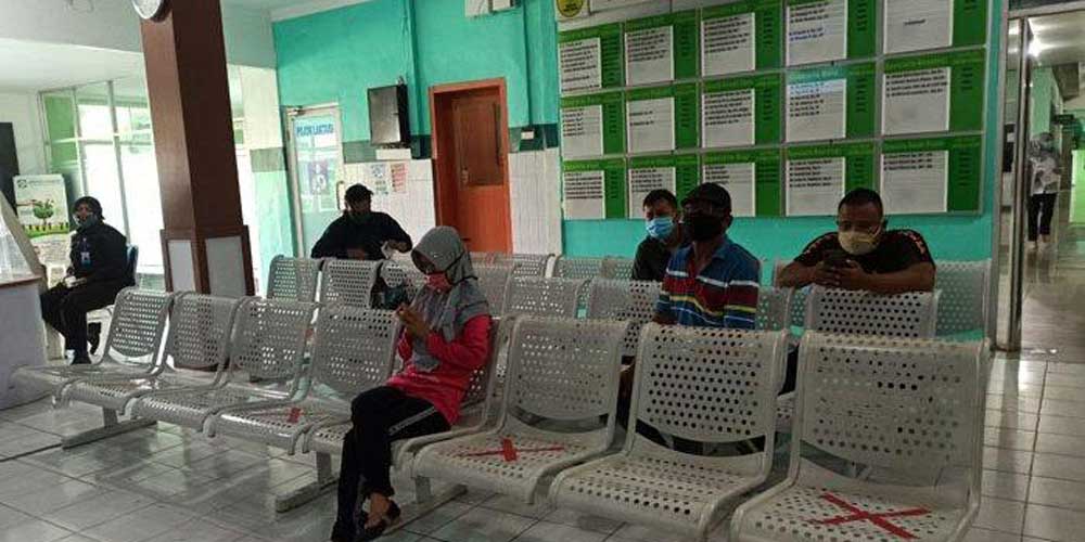 MENUNGGU: Sejumlah warga duduk di ruang tunggu RS Haji Medan. Sejak April lalu, pasien Covid-19 yang dirawat di rumah sakit milik Pemprov Sumut ini terus menurun.