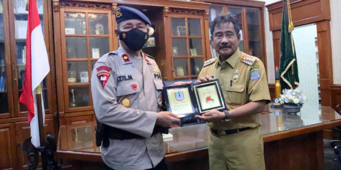 PLAKAT: Wali Kota Binjai, H Amir Hamzah saat menyerahkan plakat kepada Wadanyon A Satbrimob Polda Sumut, Kompol Azis Manan.