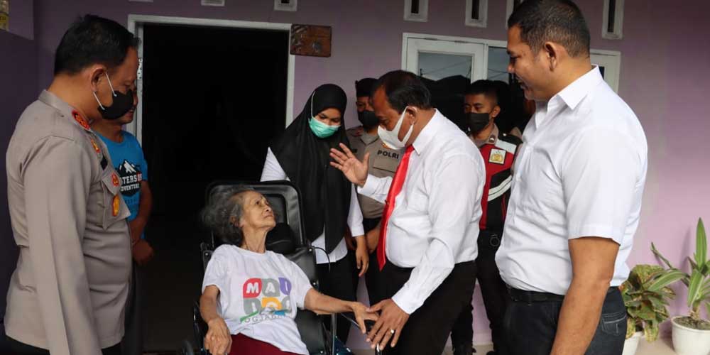 KURSI RODA: Kapolres Dairi AKBP Wahyudi Rahman (kiri) didampingi Kasat Reskrim, AKP Rismanto Purba (kanan) dan KBO IPTU Sumitro Manurung menyerahkan bantuan kursi roda kepada, Rosina Silitonga nenek berusia 80 tahun warga jalan Lestari, Desa Kalang, Kecam