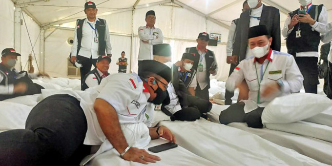 istimewa/Sumut Pos JAJAL FASILITAS: Menag Yaqut Cholil Qoumas berbaring di kasur yang dibungkus seprai putih saat meninjau fasilitas bagi jamaah haji di Arafah, Selasa (5/7).