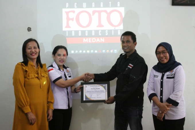 Ketua PFI Medan Rahmad Suryadi menyerahkan buku pemenang Anugerah Pewarta Foto Indonesia tahun 2022 kepada Dekan FISIP UDA Priet Sawenny  RT Simamora, S, Sos, MSi didampingi Dosen Pengampu Fotografi Jurnalistik Rahel Sukatendel, S, Sos, MSi dan Kaprodi Il