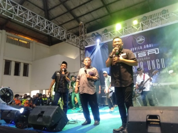 BERNYANYI: Vokalis Band Pash Ungu bernyanyi bersama Wakil Bupati Deliserdang M Yusuf Siregar pada konser amal Yayasan Banyak Sedekah Aja (BSA) di GOR Deliserdang Lubukpakam, Selasa (8/8/2022). (IST)