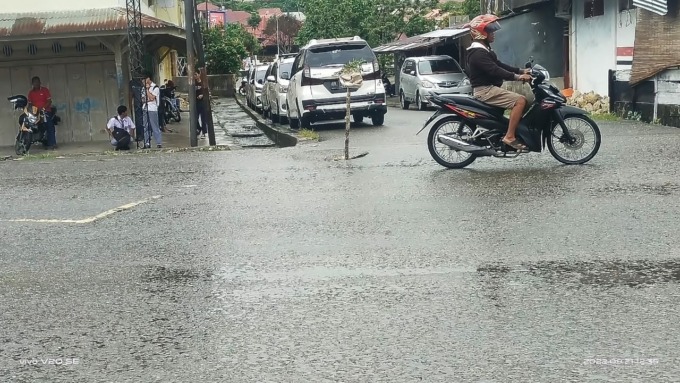 Berlubang : Jalan berlubang di simpang lima dekat Polres Nisel, ditanam sebatang kayu dibungkus karung bekas.