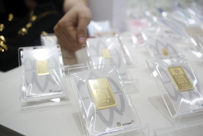 TUNJUKKAN: Seorang penjual saat menunjukkan emas yang dijualnya. Dery Ridwansah/JawaPos.com.