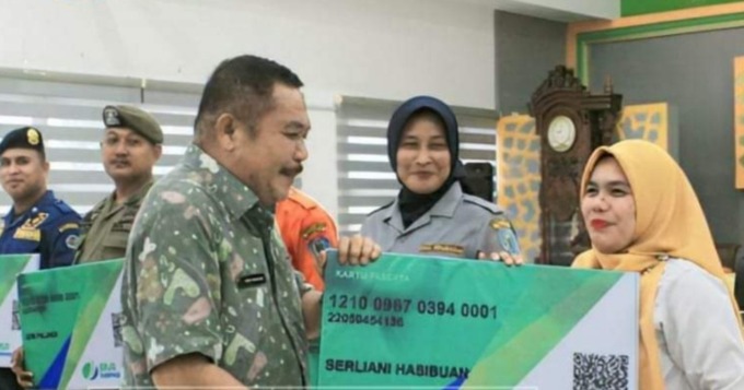 SERAHKAN: Sekda Labuhanbatu Muhammad Yusuf Siagian menyerahkan secara simbolis Kartu Kepesertaan BPJS Ketenagakerjaan Non ASN. fajar dame/SUMU POS.