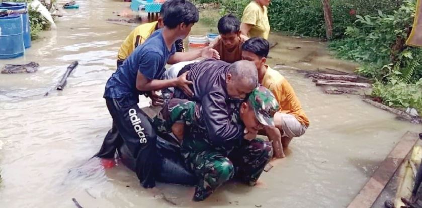BANTU EVAKUASI: Personel TNI membantu evakuasi warga lansia dari banjir yang melanda Aek Kanopan, Labura, Kamis (3/11). istimewa/sumutpos.