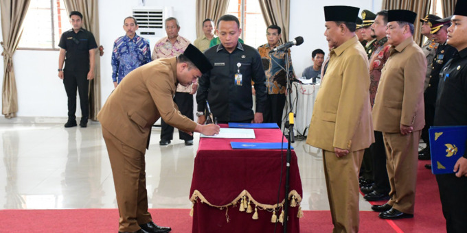 SAKSIKAN: Timur Tumanggor menandatangani berita acara pelantikan disaksikan Bupati Deliserdang, Ashari Tambunan.BATARA/SUMUT POS .